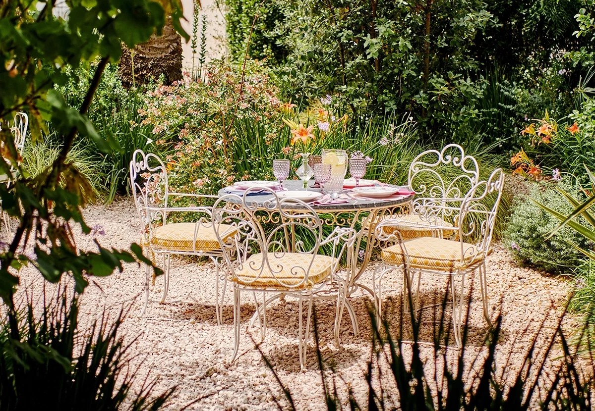 De geheime stadstuin van La Cocina de Cristine met tafeltjes tussen de planten in Maó
