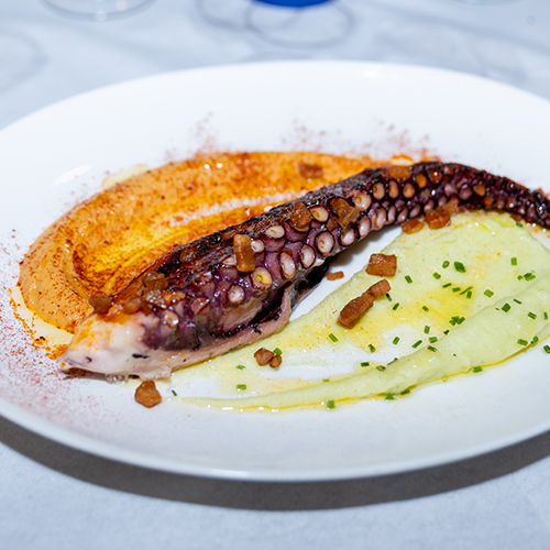 Gegrilde octopus (pulpo a la brasa) op een bord bij La Guapa in Fornells