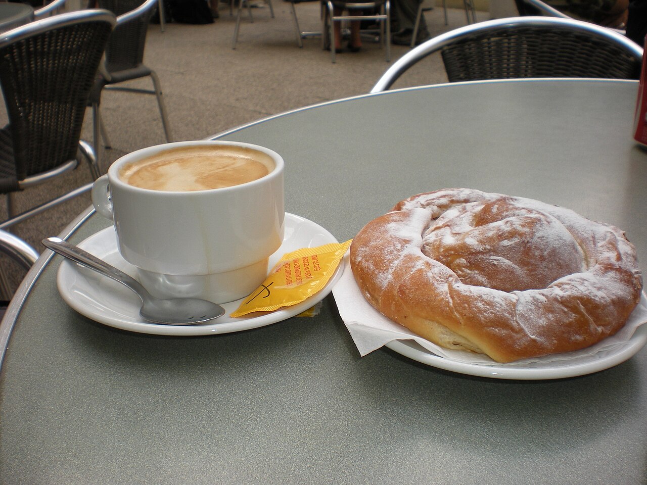 Ensaïmada met een café amb llet op een terras op Mallorca