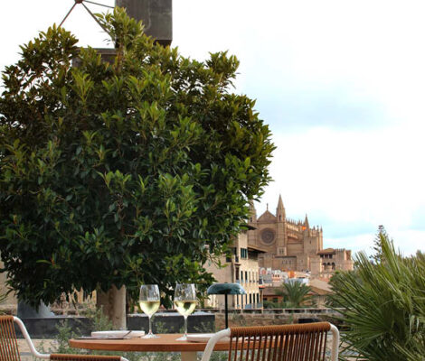 Gedekte tafel met wijnglazen op het terras van Mariluz met de kathedraal van Palma op de achtergrond