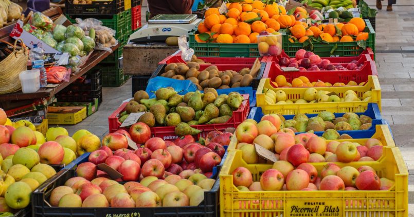 Fruitkraam op de weekmarkt van Santanyí op Mallorca met kratten appels, peren, kiwi's en sinaasappels