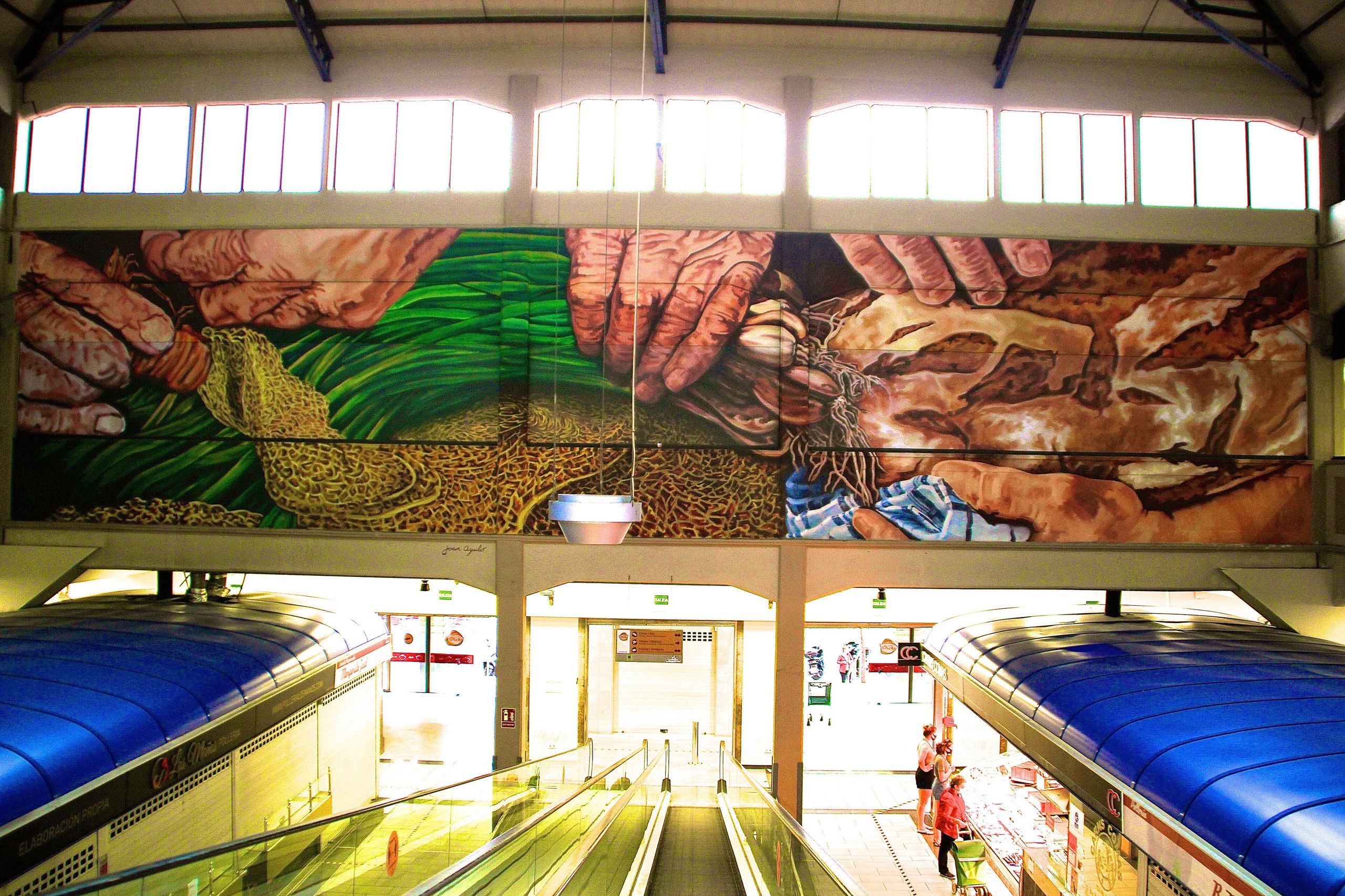 Interieur van de overdekte markthal Mercat de l'Olivar in Palma met roltrappen en een muurschildering van boerenhanden
