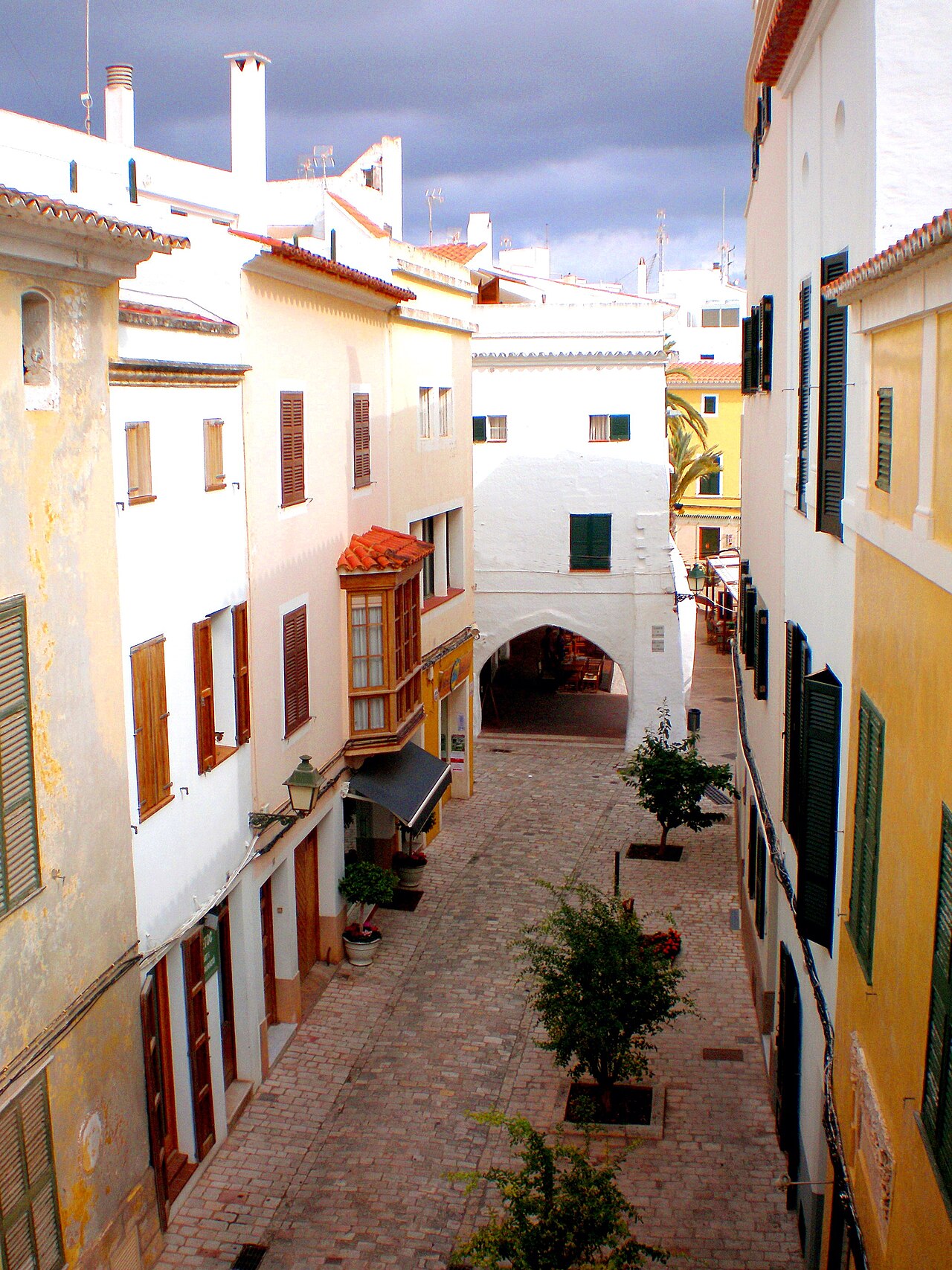 Witte straat met bloembakken in een dorp op Menorca