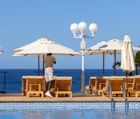 Het zwembad en de parasols van Mhares Sea Club met de Baai van Palma erachter