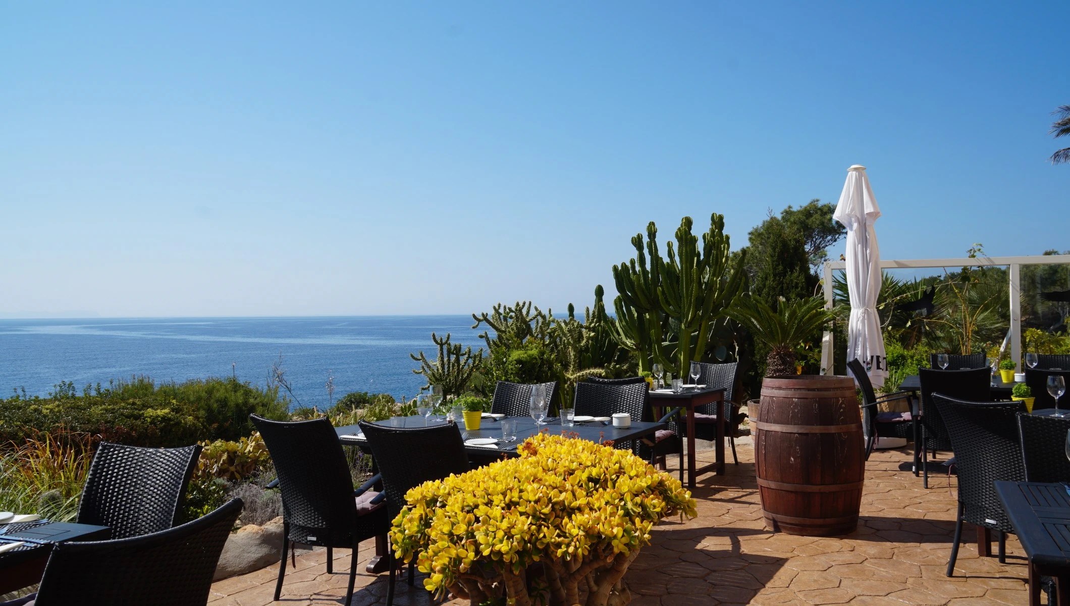 Terras van Mirador de Cabrera met tafels en zicht over de zee bij Cala Pi