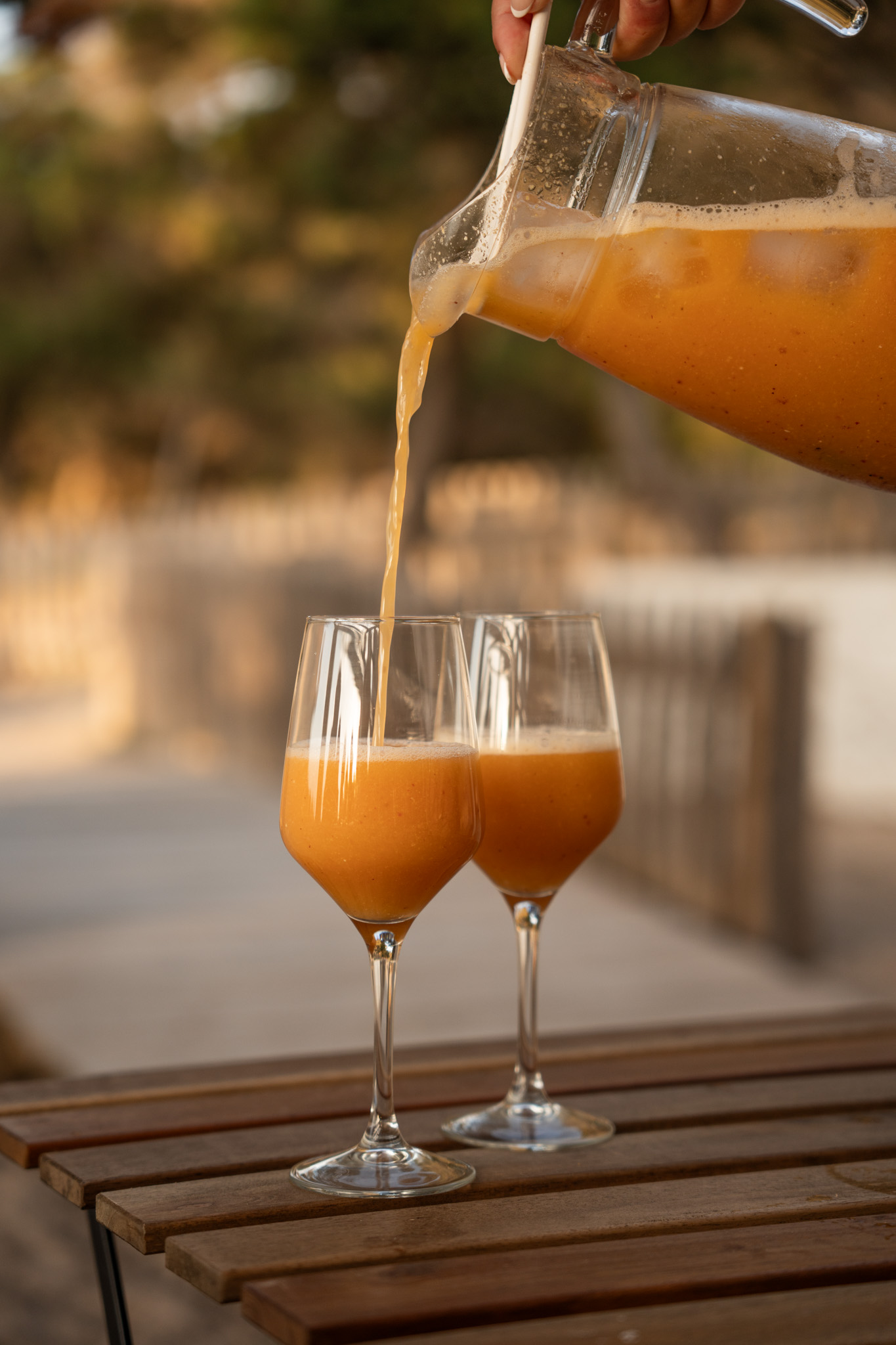 Ñora Beach Ibiza: strandrestaurant en ligbedden aan Port des Torrent 9 Twee glazen worden ingeschonken op het terras van Ñora Beach