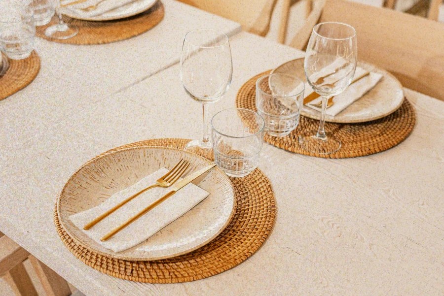 NU Mallorca: beachclub en restaurant op Playa de Muro (baai van Alcúdia) 6 Een gedekte tafel met glaswerk en gouden bestek bij NU Mallorca