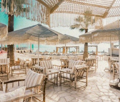 Het terras met parasols en tafels van NU Mallorca aan het strand van Playa de Muro