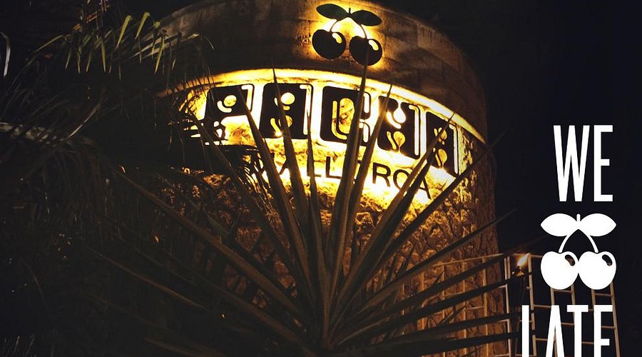De entree van Pacha Mallorca met de verlichte letters PACHA op de stenen toren en het overdekte terras ernaast