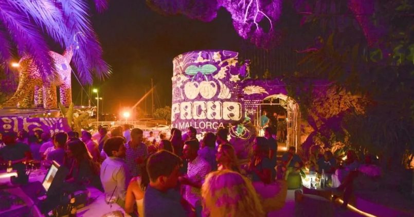 Het verlichte terras van Pacha Mallorca aan de Paseo Marítimo in Palma op een zomeravond, met de karakteristieke ronde toren met het kersenlogo