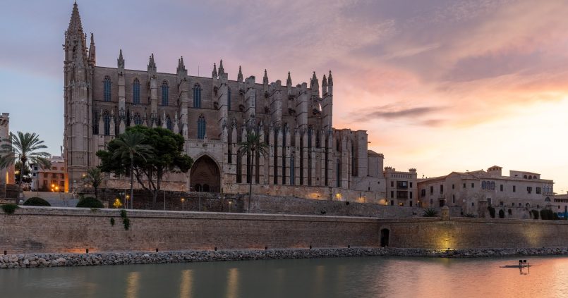 Kathedraal van Palma bij zonsopkomst boven het meer van het Parc de la Mar, waaronder de parkeergarage ligt