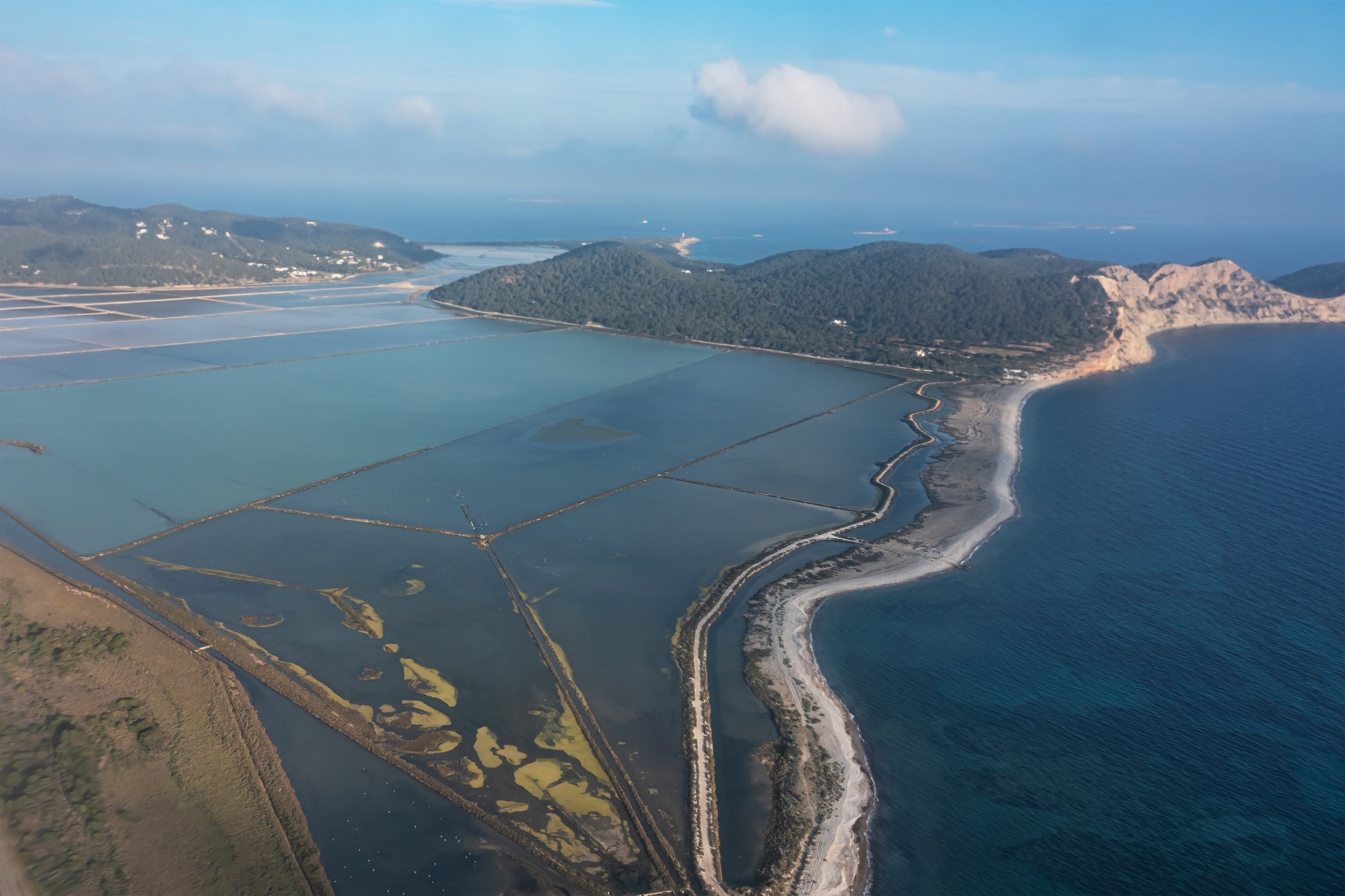 Platja des Codolar Ibiza: het langste, wildste strand van het eiland 1 Luchtfoto van Platja des Codolar op Ibiza: een lange kiezelstrook tussen de zoutpannen van Ses Salines en de zee, met de kliffen van Cap des Falcó