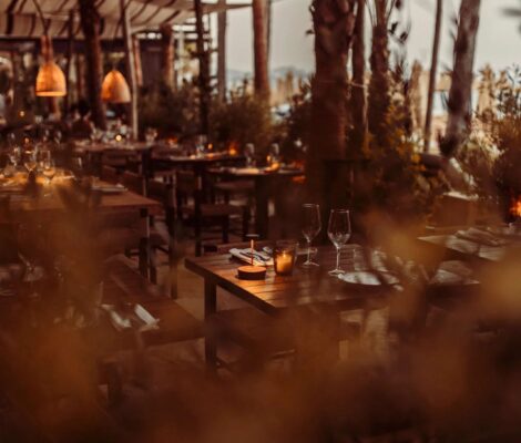 Het overdekte terras van Playa Soleil op Ibiza in de schemering, met hangende lampen
