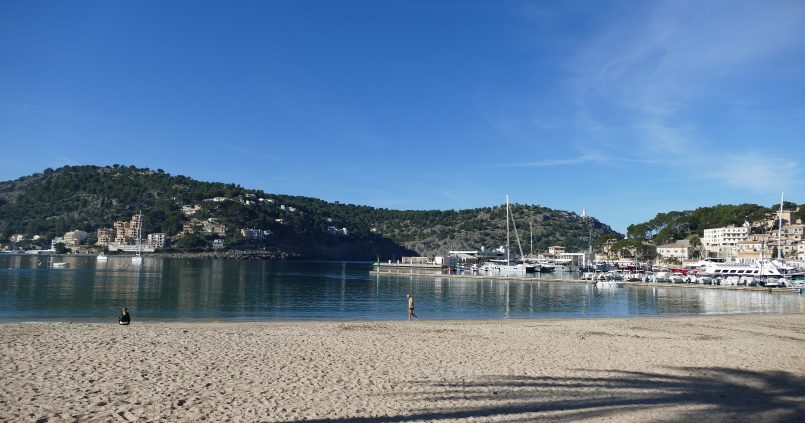 Het strand van Port de Sóller op Mallorca met licht zand, de bijna ronde baai, de jachthaven en de beboste bergen van de Tramuntana eromheen