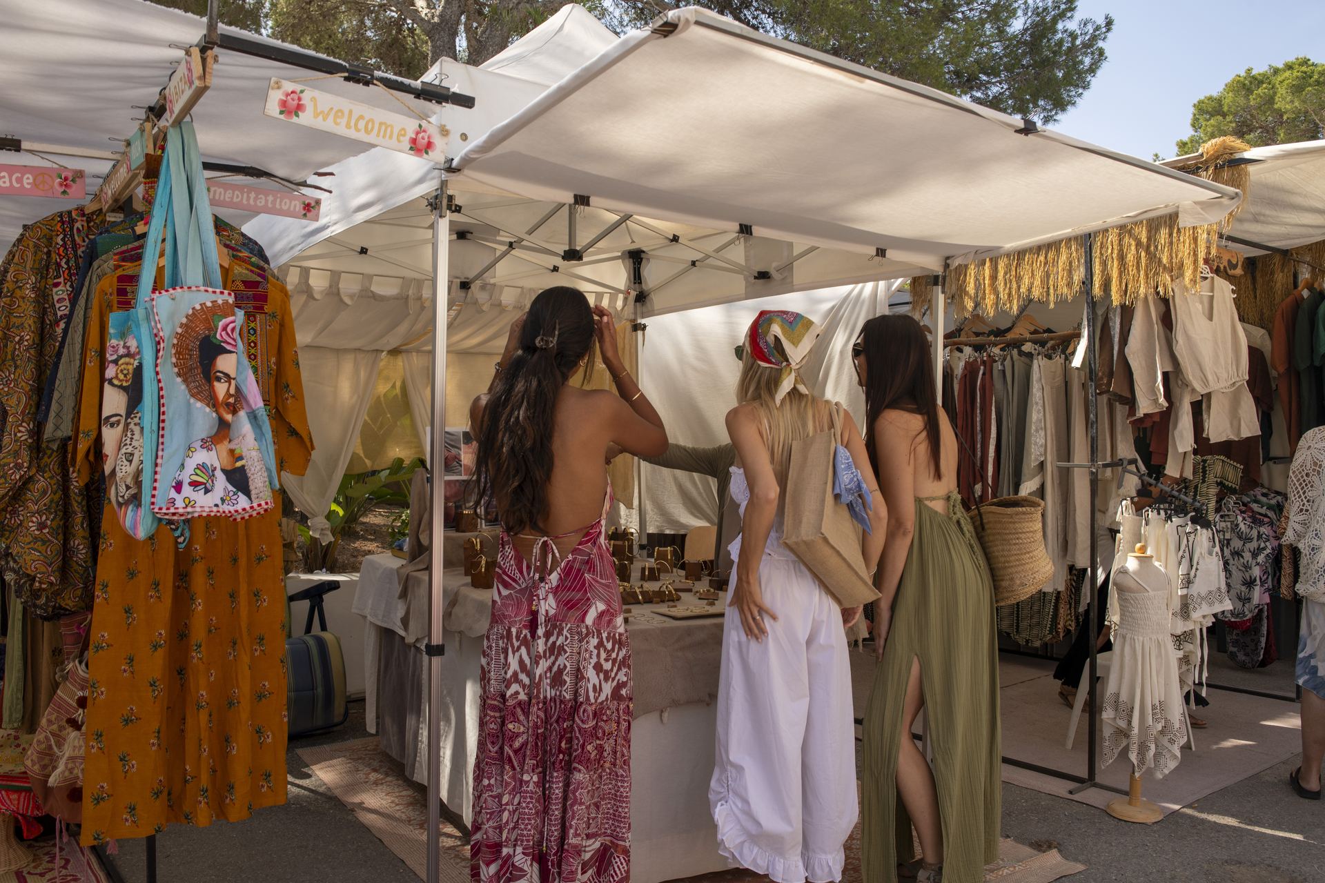 Punta Arabí Ibiza: de oudste hippiemarkt van het eiland, sinds 1973 2 Kramen met kleding, tassen en linnen onder witte partytenten op de hippiemarkt van Punta Arabí
