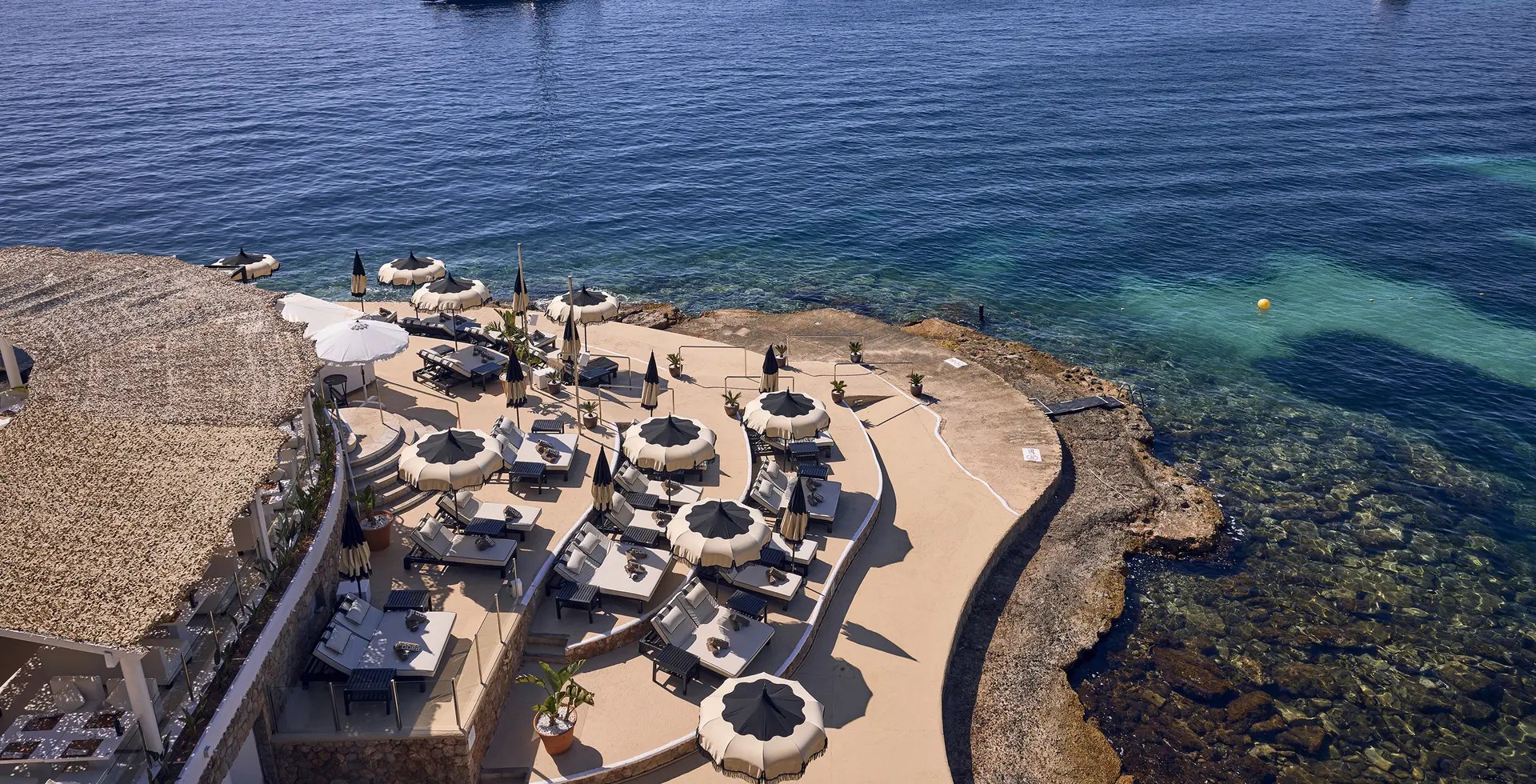 Luchtfoto van de rotspunt van Purobeach Illetas met parasols en zeebad