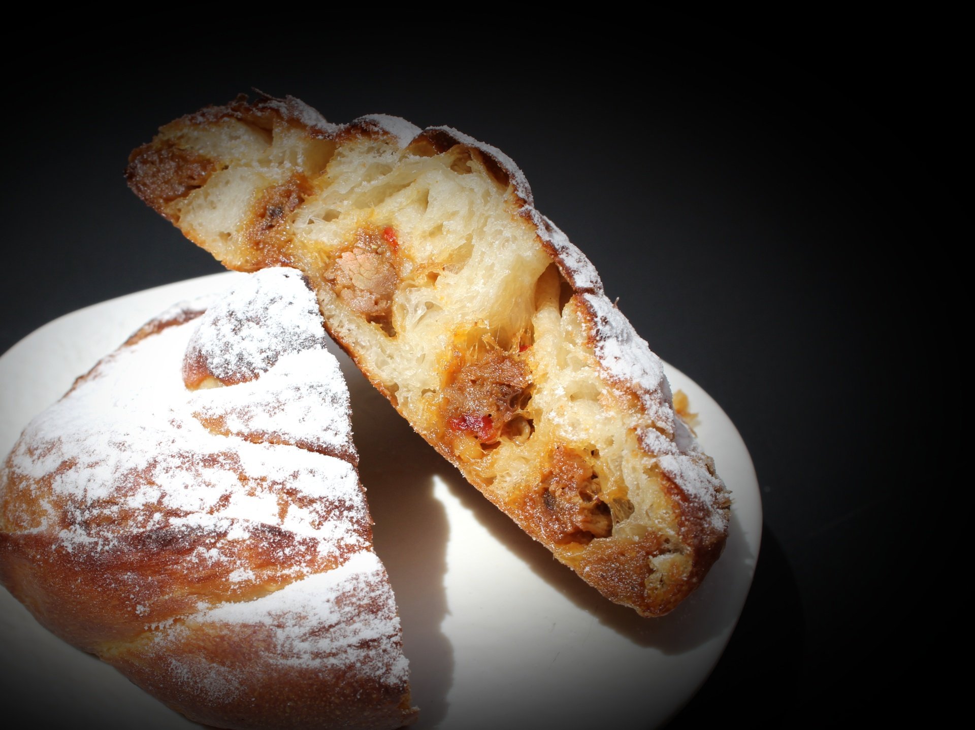 Sa Clastra bij Es Capdellà: een sterrenmenu van negen winden 7 Brood van het huis bij restaurant Sa Clastra op Mallorca, doorgesneden op een zwarte achtergrond
