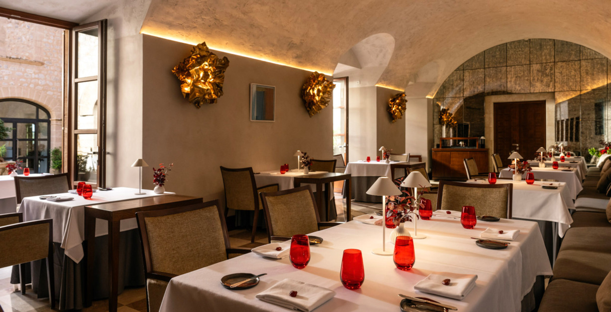 Sa Clastra bij Es Capdellà: een sterrenmenu van negen winden 9 De eetzaal binnen van restaurant Sa Clastra op Mallorca met witte tafels en rode glazen