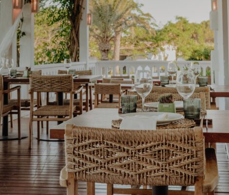 Het terras met gedekte tafels en palmen bij restaurant Sant Joan de Binissaida op Menorca
