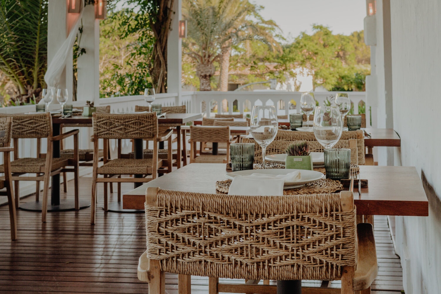 Het terras met gedekte tafels en palmen bij restaurant Sant Joan de Binissaida op Menorca