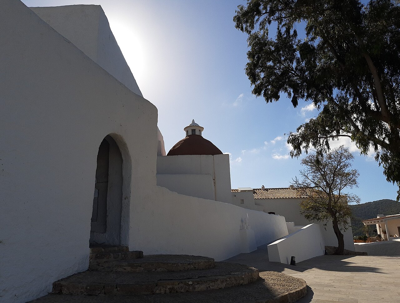 Het witte, overdekte voorportaal en het terracotta koepeltje van de kerk op de Puig de Missa in Santa Eulària des Riu