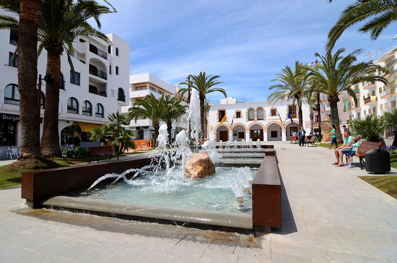 De Plaça d'Espanya in Santa Eulària des Riu met de fontein, de palmen en het witte gemeentehuis met zijn bogen