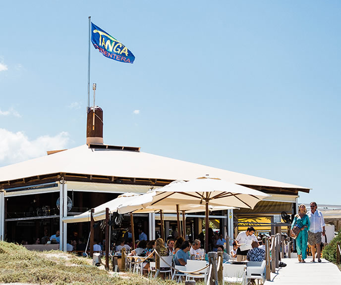 Het strandrestaurant Tanga met zijn gele vlag en volle terras aan Platja de Llevant op Formentera