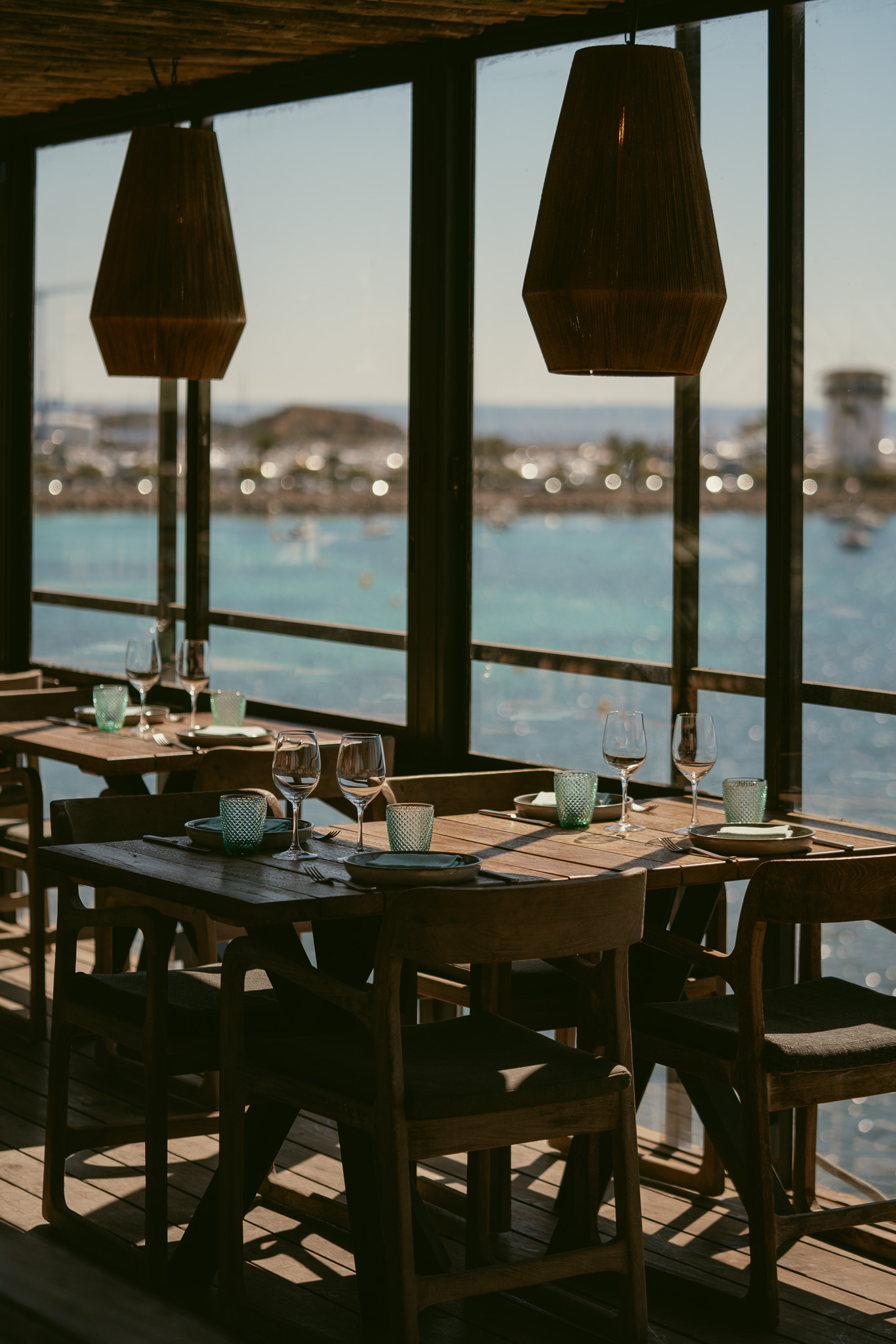 Gedekte tafels in het restaurant van UM Beach House met uitzicht op zee
