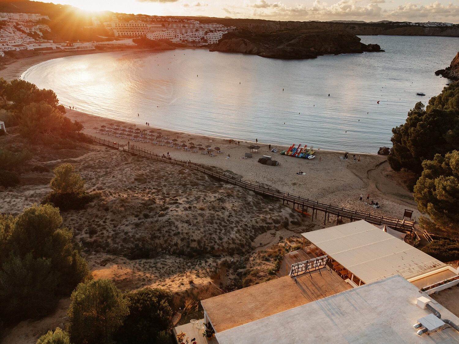 De baai van Arenal d'en Castell bij zonsondergang met het terras van Viva La Pepa