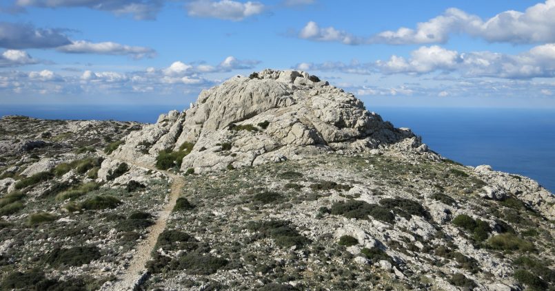 Stenen wandelpad naar de rotstop van es Caragolí boven Valldemossa met de zee op de achtergrond