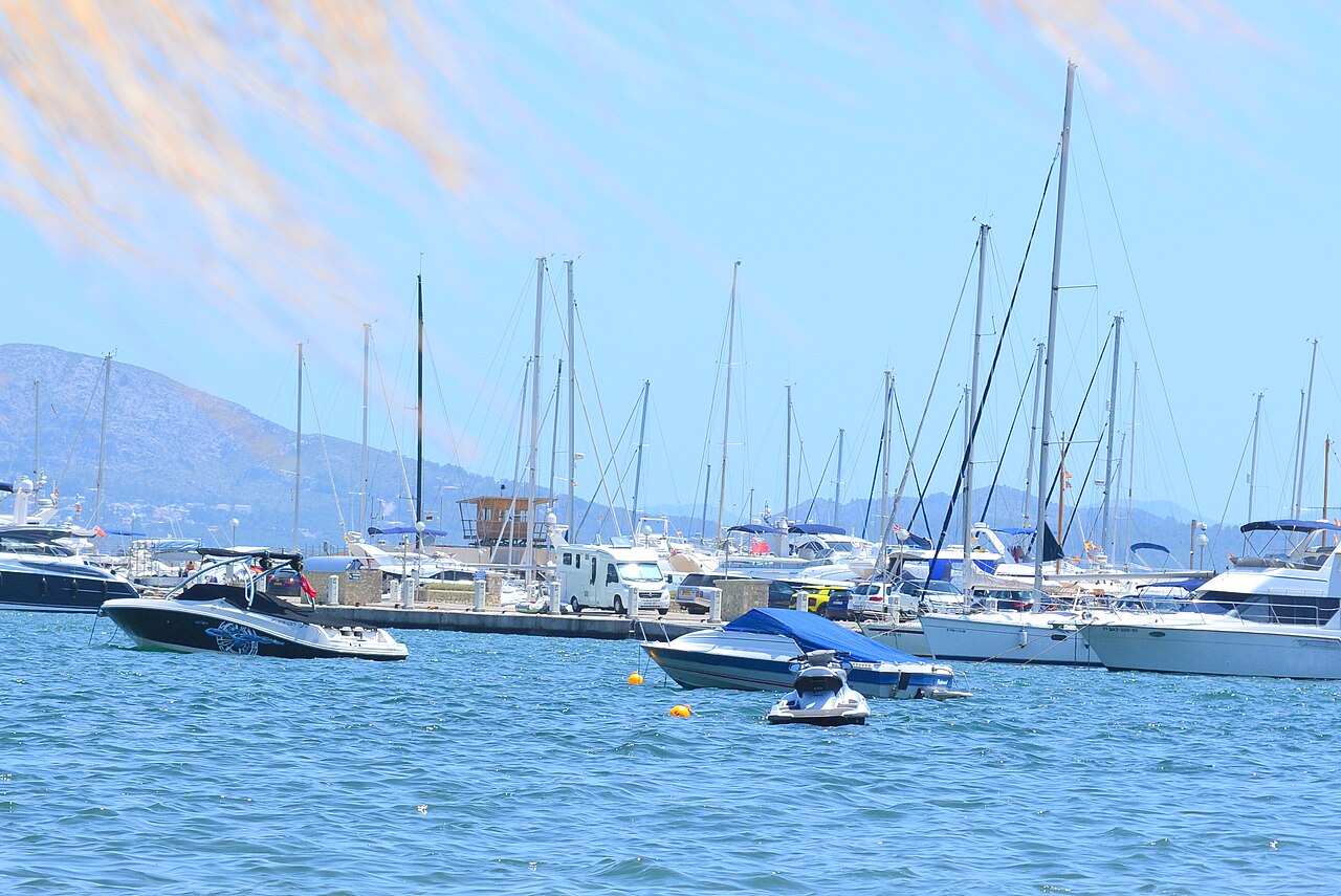 Wanneer boek je een vakantie naar de Balearen het goedkoopst? 1 Boten in de jachthaven van Port de Pollença op Mallorca, met de bergen van de Serra de Tramuntana erachter