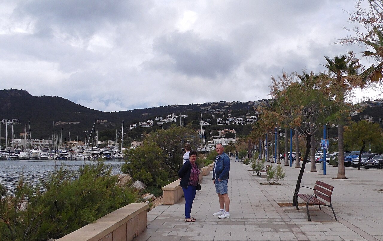 Wanneer boek je een vakantie naar de Balearen het goedkoopst? 2 De boulevard langs de haven van Port d'Andratx op Mallorca, met palmbomen en wandelaars