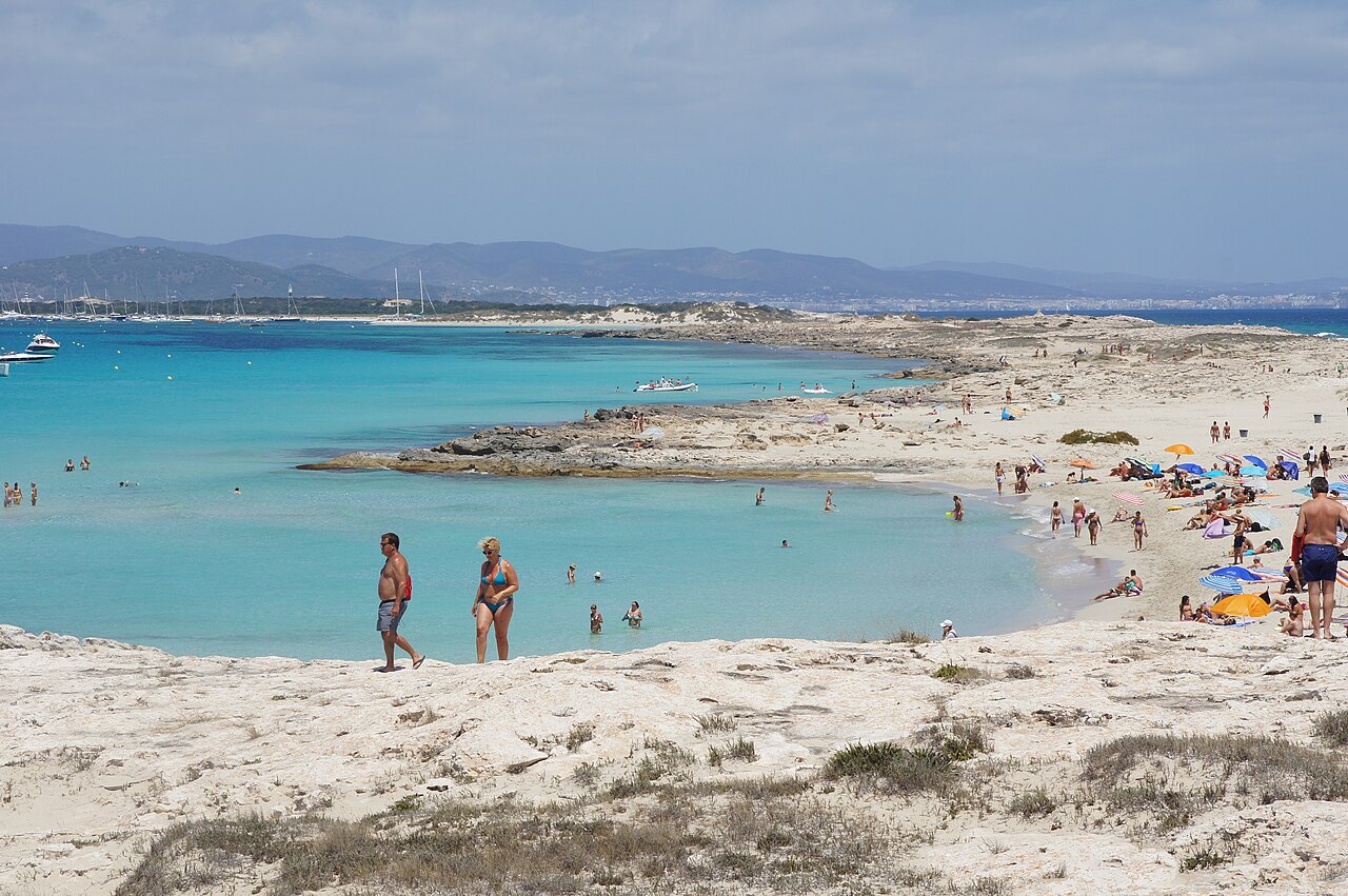 Wanneer boek je een vakantie naar de Balearen het goedkoopst? 7 Ondiep turquoise water bij Ses Illetes op Formentera met badgasten op de zandbank