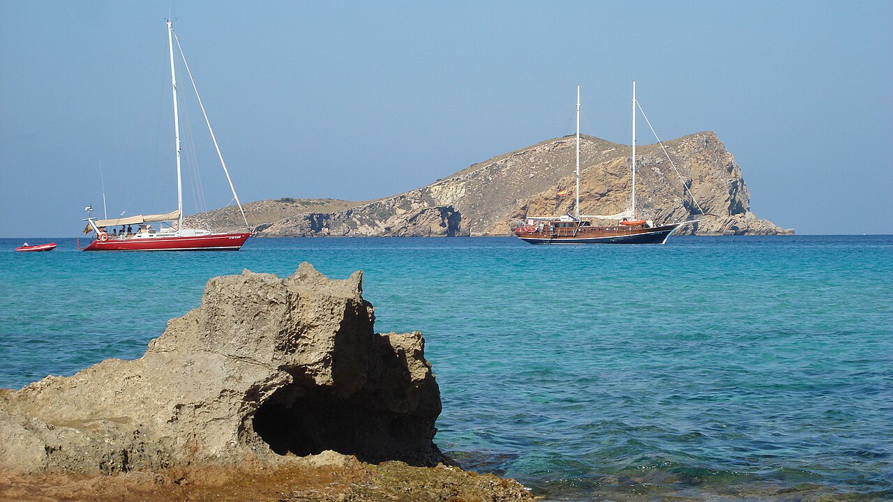Welk Balearen-eiland past bij jou? 4 Zeilboten voor de kust bij Cala Comte op Ibiza, met het rotseiland Sa Conillera op de achtergrond