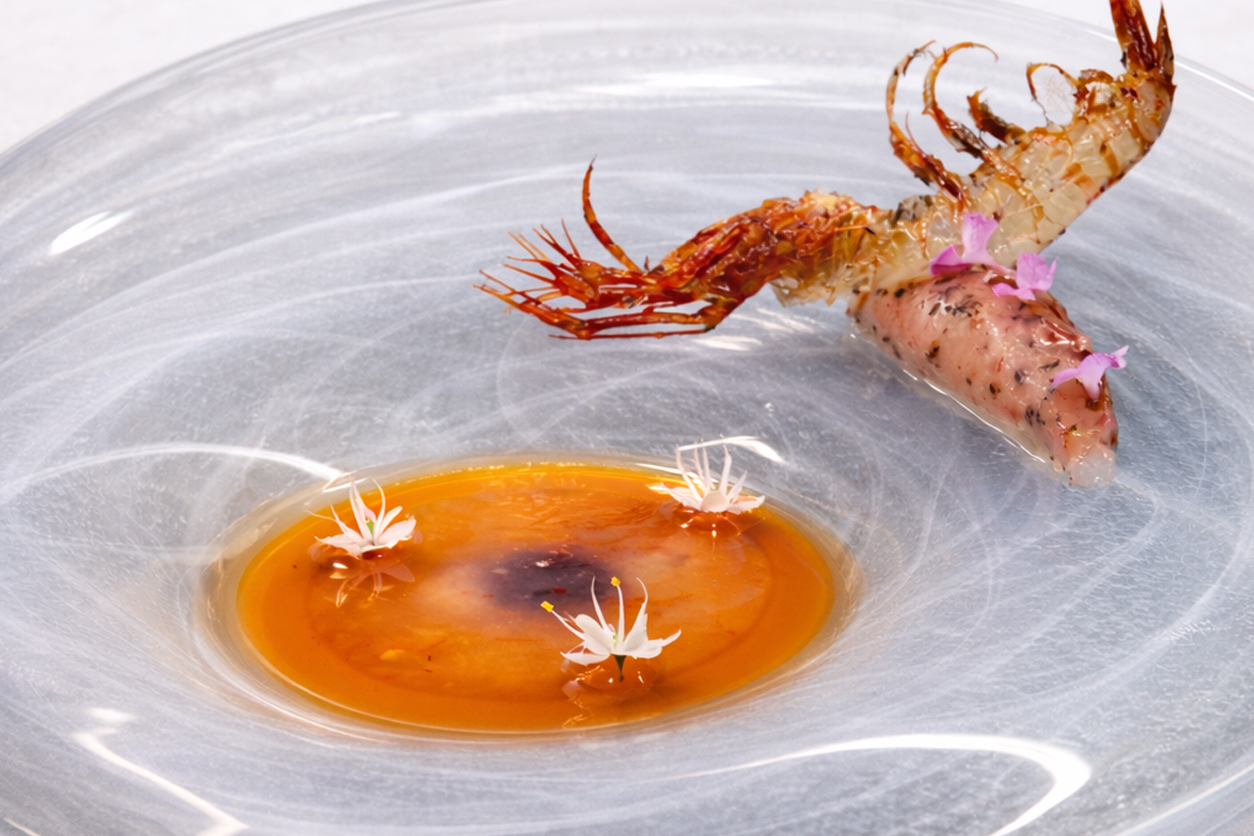 Een gerecht van Zaranda in Palma met een langoustine boven een heldere gelei en eetbare bloemen