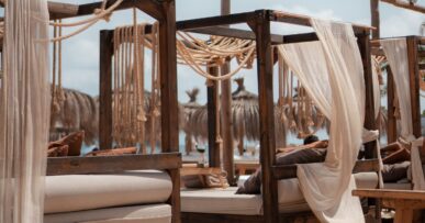 Het terras van Zazú Ibiza met loungebedden en witte zeilen