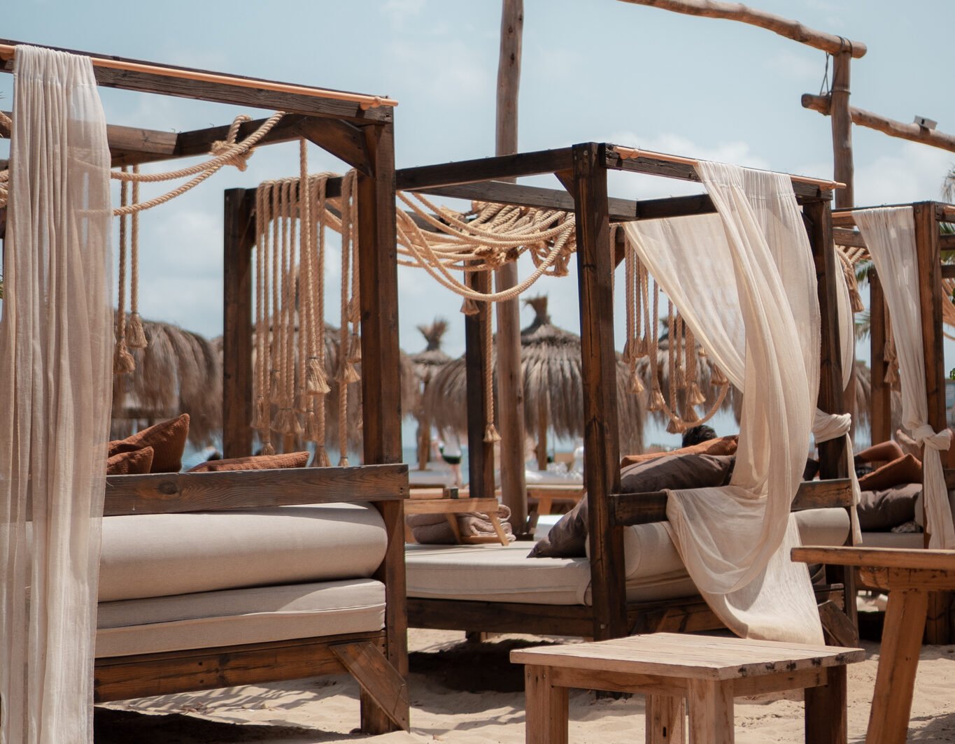 Het terras van Zazú Ibiza met loungebedden en witte zeilen
