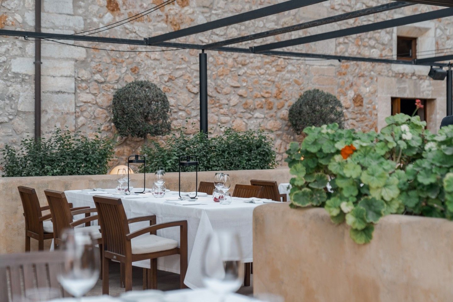 365 bij Son Brull (Pollença): het menu uit de eigen finca 4 Het terras van restaurant 365 met geraniums, buxusbollen en de oude gevel van Son Brull