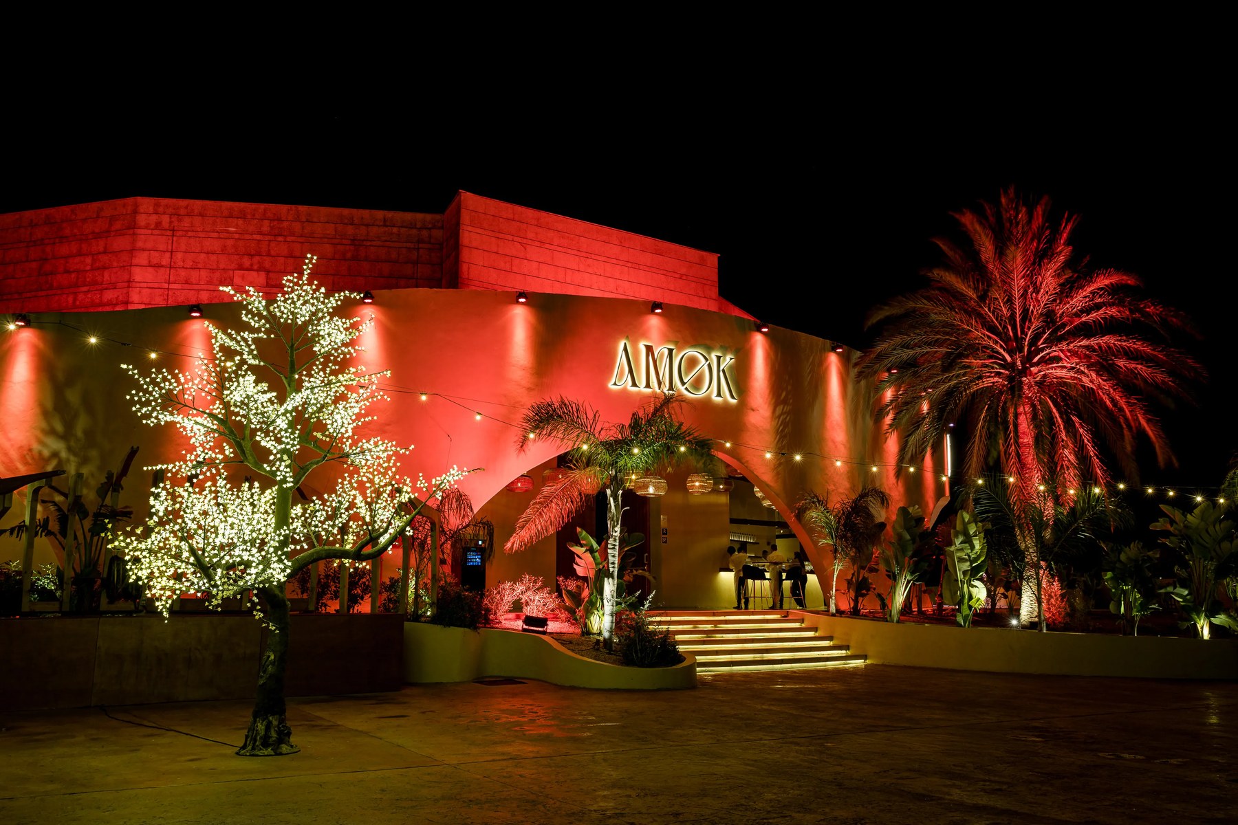 De rood uitgelichte gevel van club Amok bij Palma met de lichtgevende naam boven de ingang