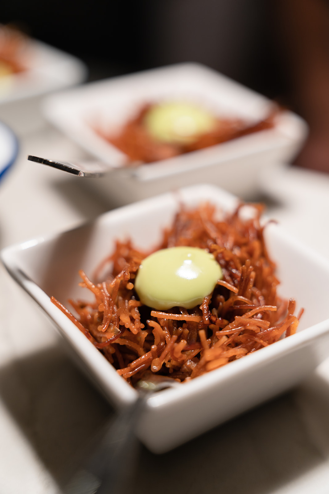 Andana Palma: eten in het eerste treinstation van Mallorca 8 Vierkante schaaltjes met krokant gefrituurde reepjes en een dot lichtgroene mayonaise, hapje van restaurant Andana in Palma