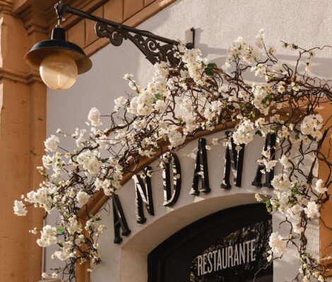 Andana Palma: eten in het eerste treinstation van Mallorca 3 De gevel van restaurant Andana in Palma met de naam in zwarte letters boven de boogdeur en witte bloesemtakken om de lantaarn