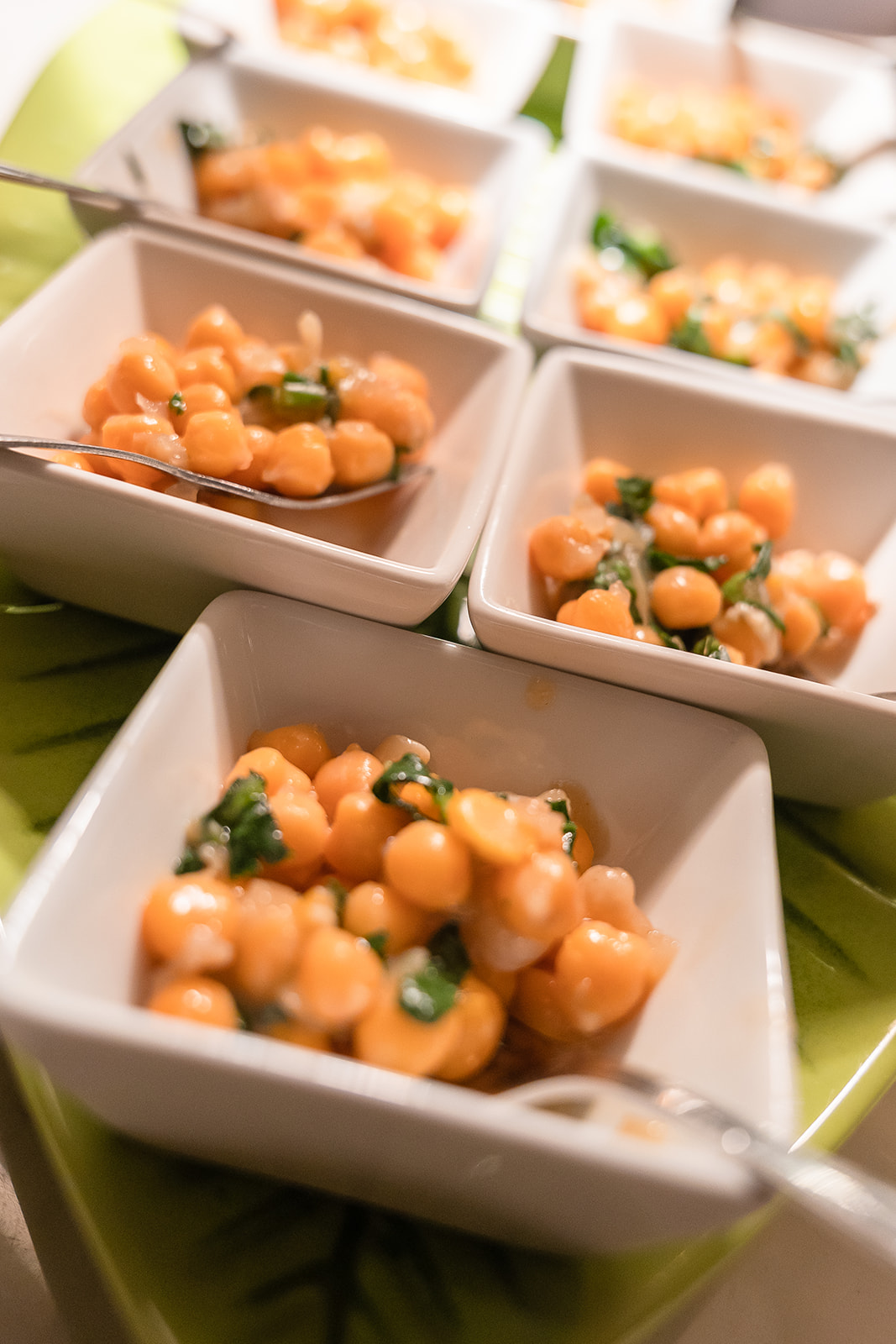 Andana Palma: eten in het eerste treinstation van Mallorca 2 Vierkante witte schaaltjes met kikkererwten en groene kruiden, klaargezet voor de gasten van Andana in Palma