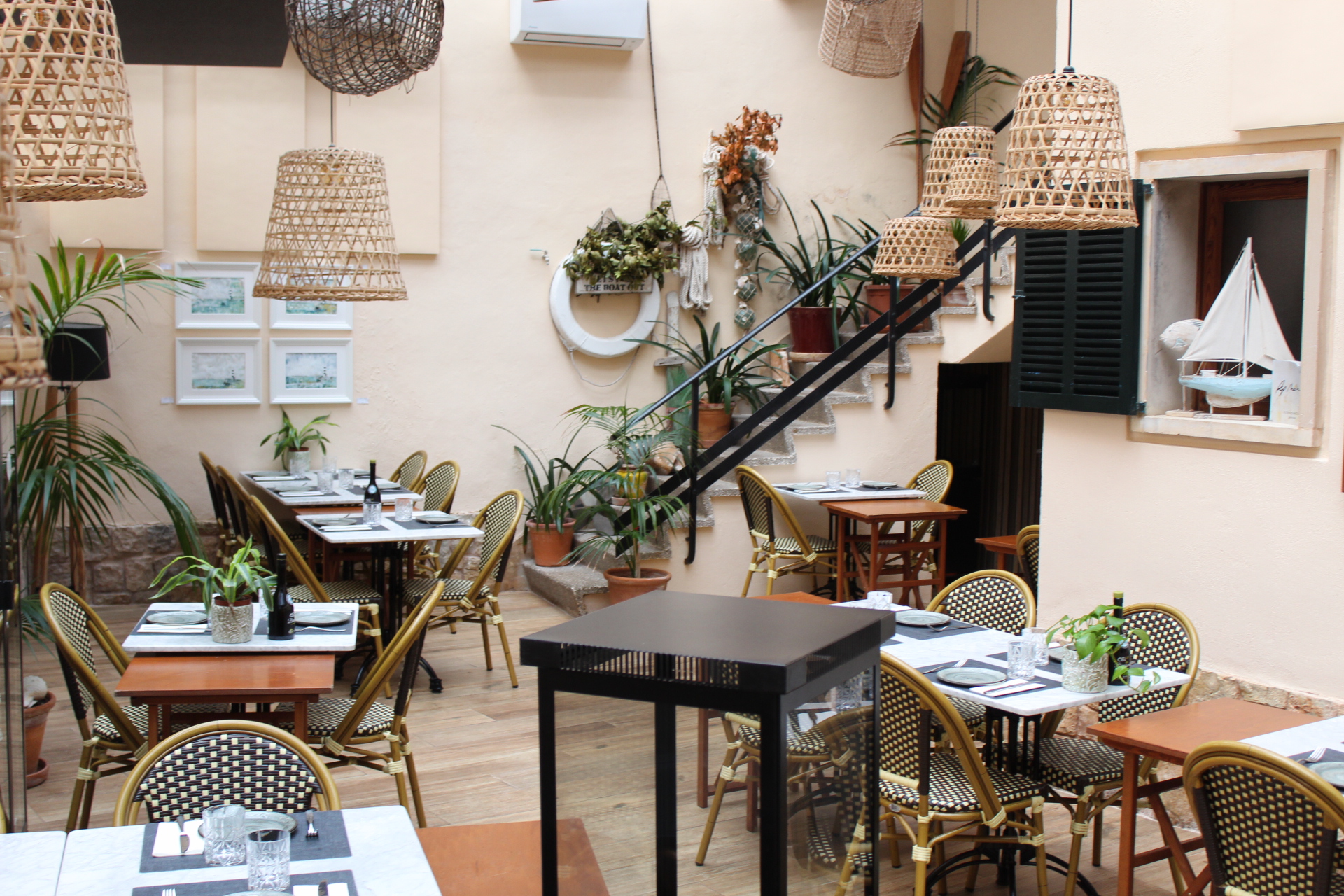 Bodega Barahona in Ses Salines: het visrestaurant dat ook Casa Manolo heet 7 De overdekte patio van Bodega Barahona met rotan hanglampen, planten en gedekte tafels met rieten stoelen