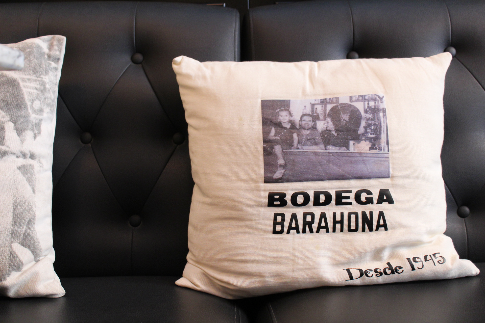 Bodega Barahona in Ses Salines: het visrestaurant dat ook Casa Manolo heet 8 Linnen kussen met de opdruk Bodega Barahona en de woorden Desde 1945 op een donkere bank in de zaal