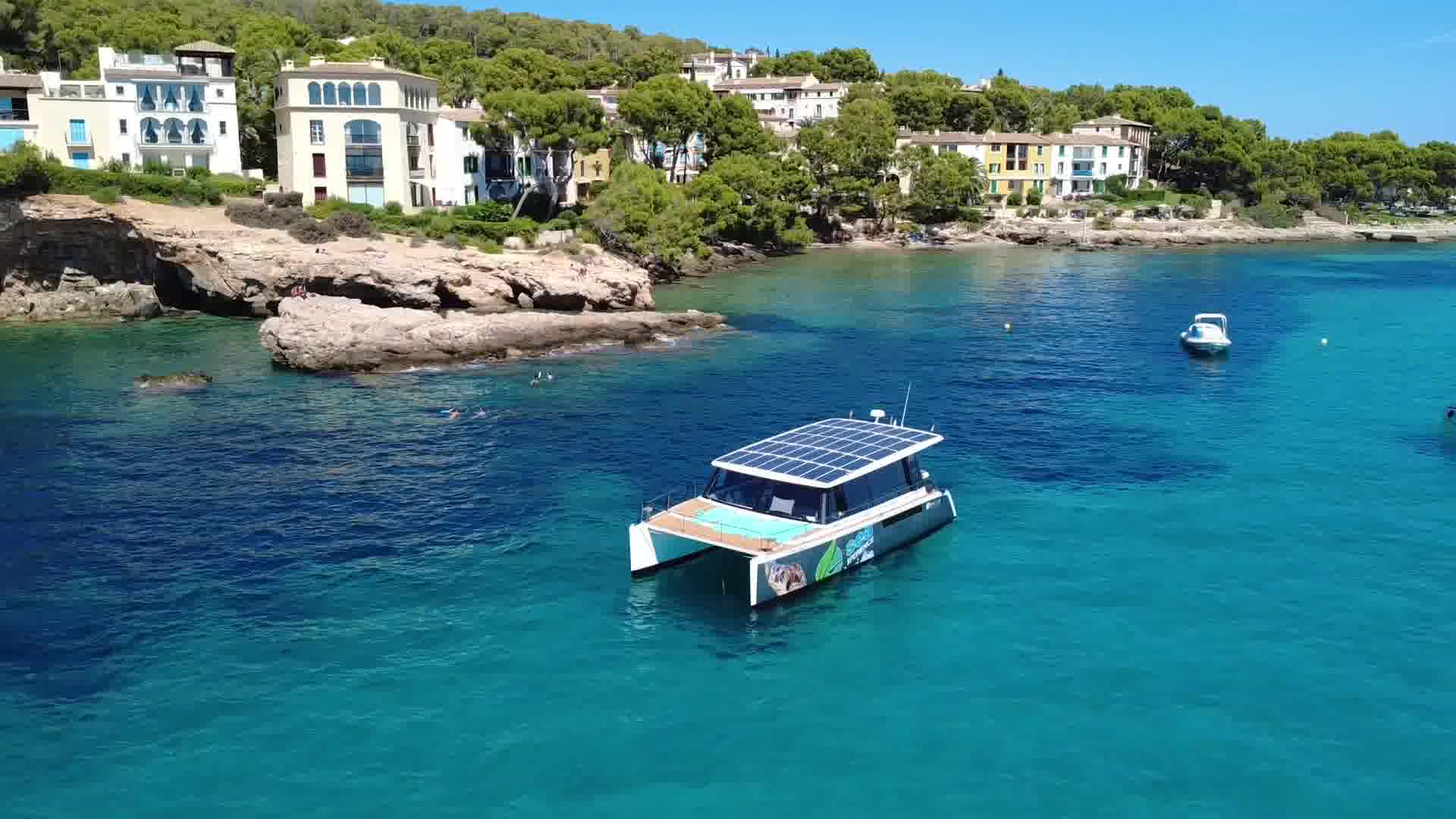 Catamaran voor anker in een turquoise baai aan de kust van Mallorca