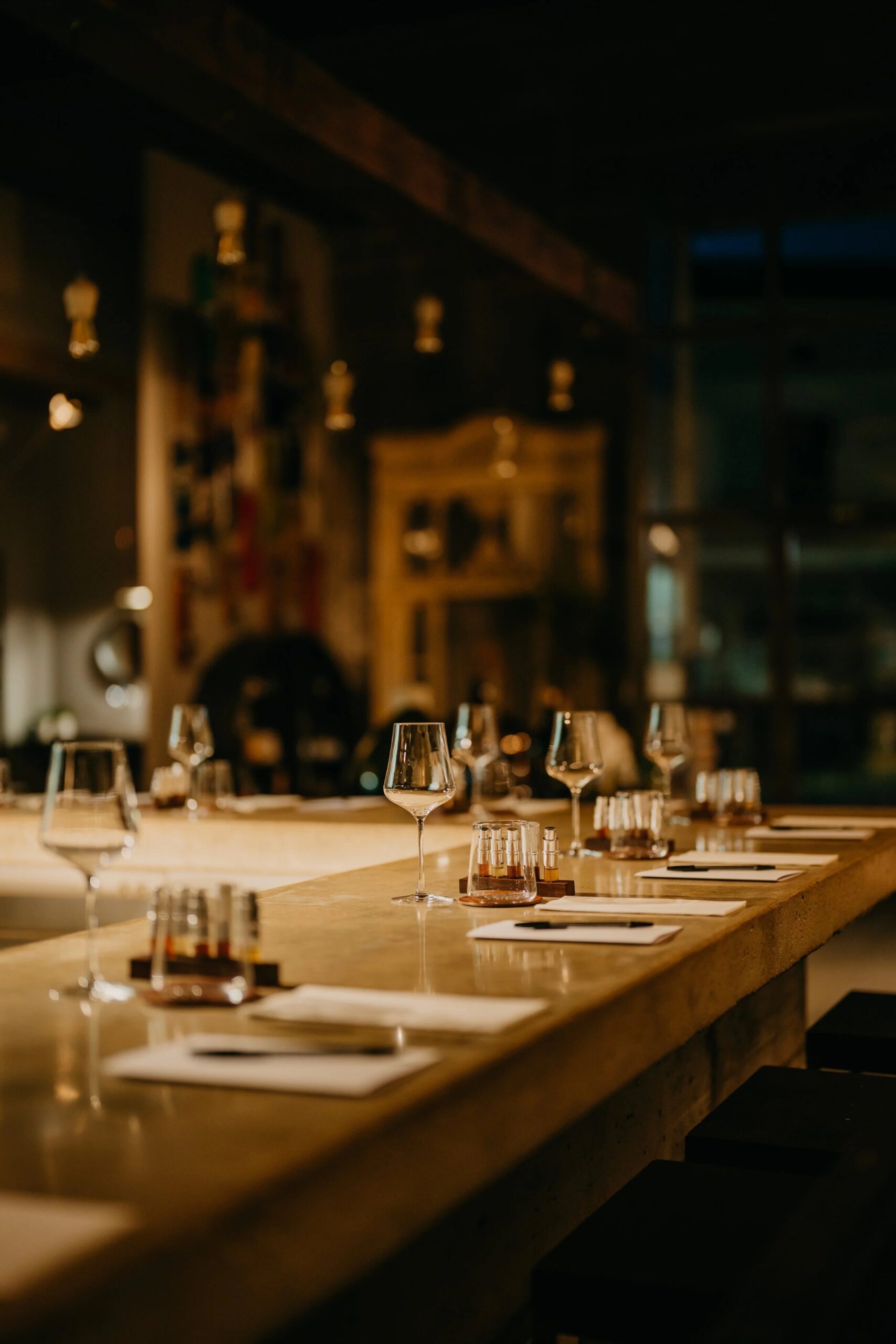 Brut in Llubí: één zitting per avond in een oude houtloods 2 De betonnen bar van restaurant Brut in Llubí, gedekt met wijnglazen en kleine flesjes voor de start van de avond