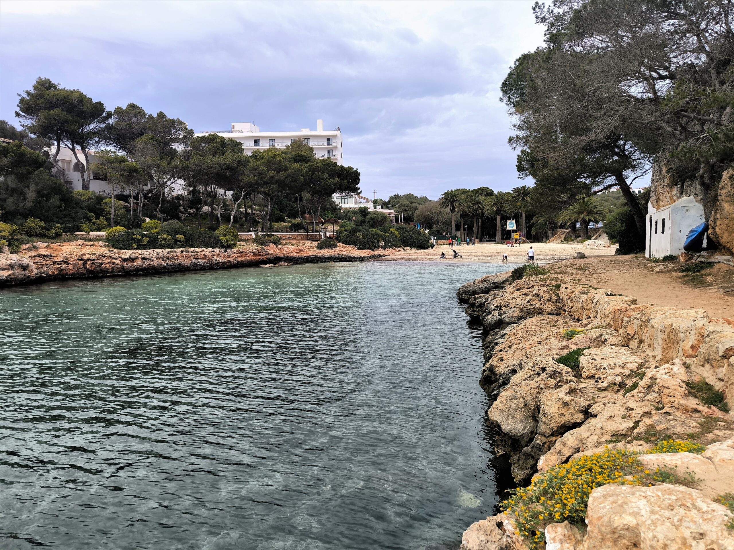 Cala en Blanes Menorca: de kloofbaai bij Ciutadella, met Cala en Forcat en Los Delfines 1 De smalle inham van Cala en Blanes met turquoise water, rotsranden en het zandstrand achter in de kloof