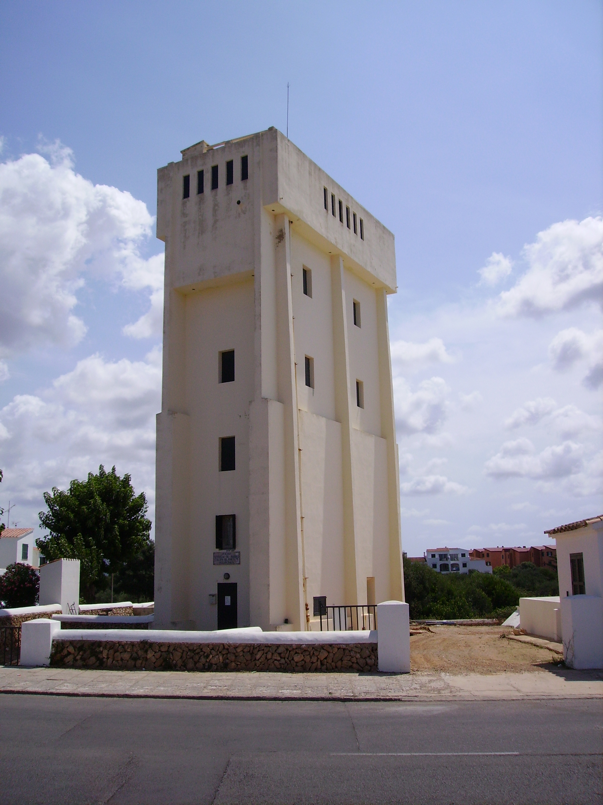Cala en Blanes Menorca: de kloofbaai bij Ciutadella, met Cala en Forcat en Los Delfines 7 De witte watertoren Torre de l'Aigua die boven de wijk Cala en Blanes uitsteekt