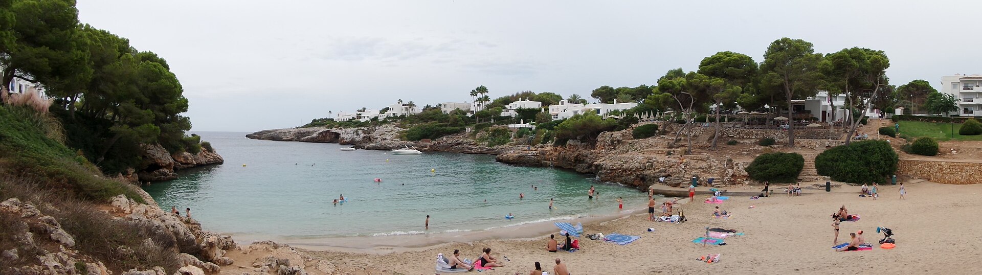 Panorama van Cala Esmeralda met de hele zandstrook, de baai en het terras van de strandbar rechts