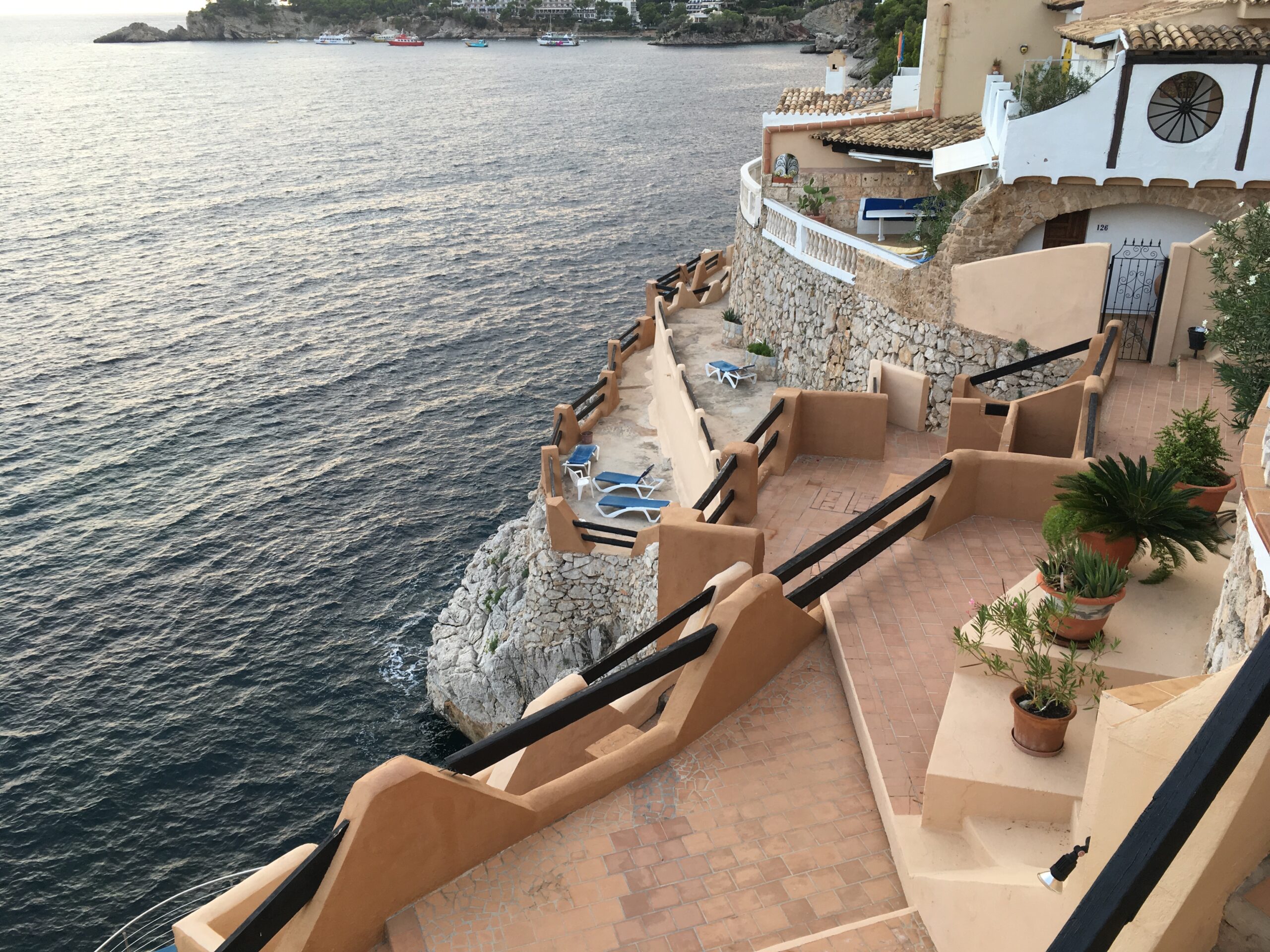 Cala Fornells (Mallorca): helder cove-resort bij Peguera 4 Terrassen met trappen en ligbedden die in Cala Fornells vanaf de gebouwen naar de zee aflopen